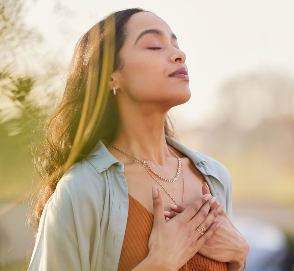 Woman outdoors touching her chest