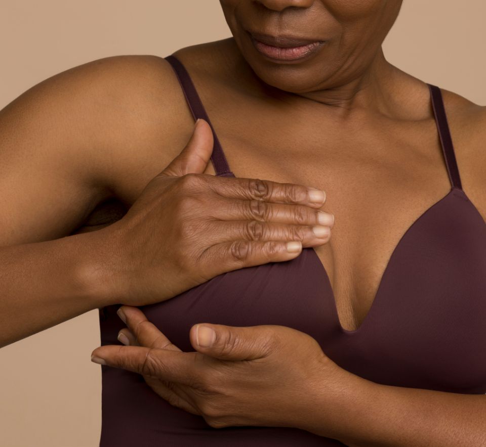 Woman touching her chest, breast examination