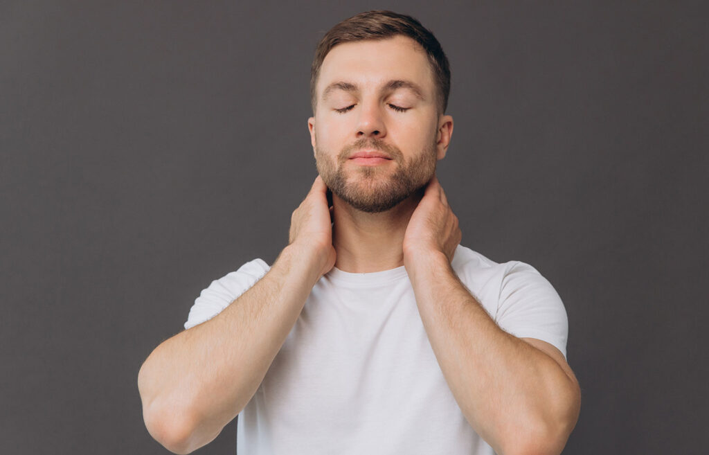 Man touching his neck